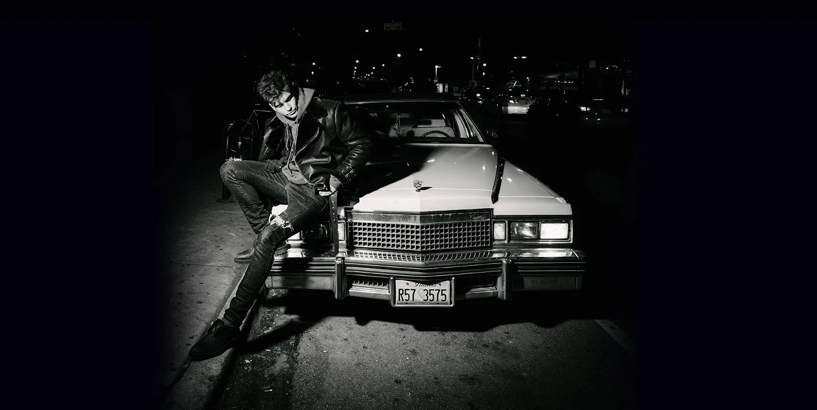 Lock & Loaded campaign: a man on the hood of a white Cadillac at night