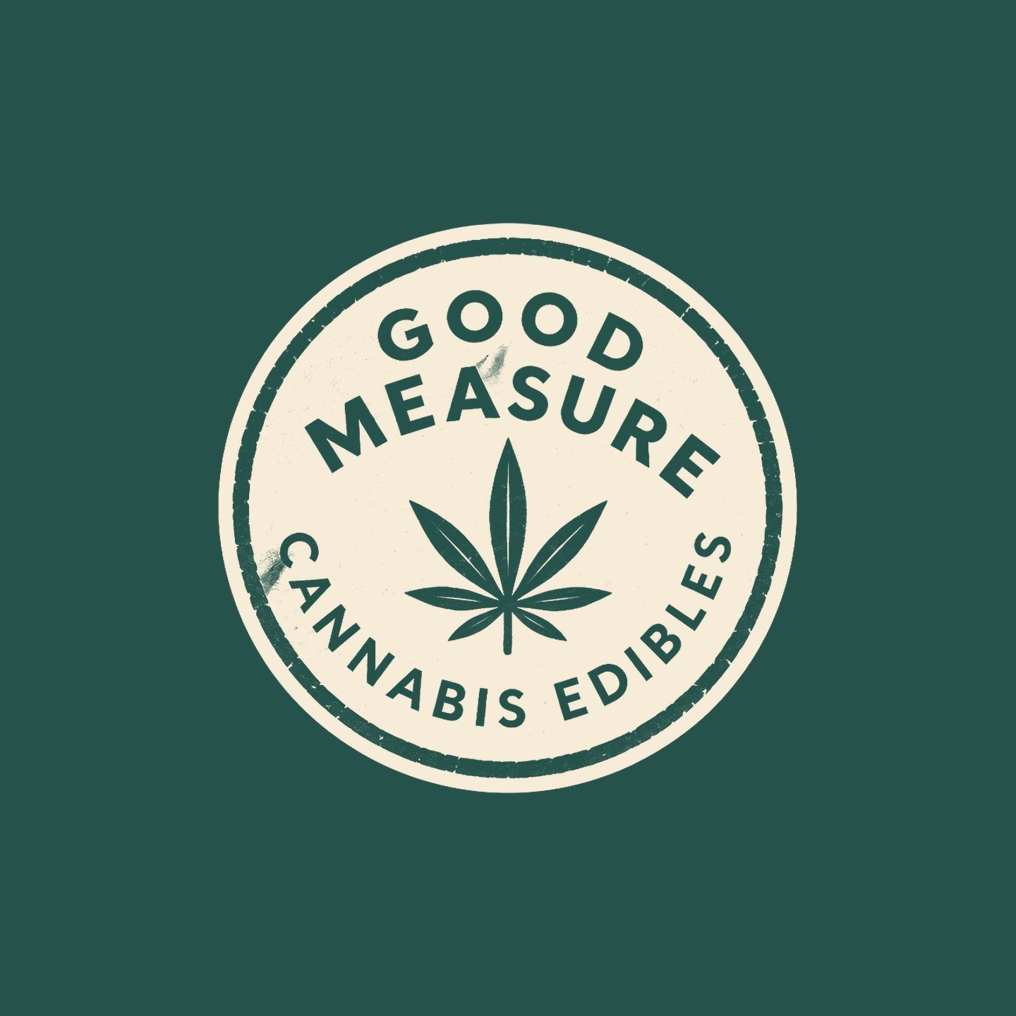 The round Good Measure cannabis edibles badge in cream on pine