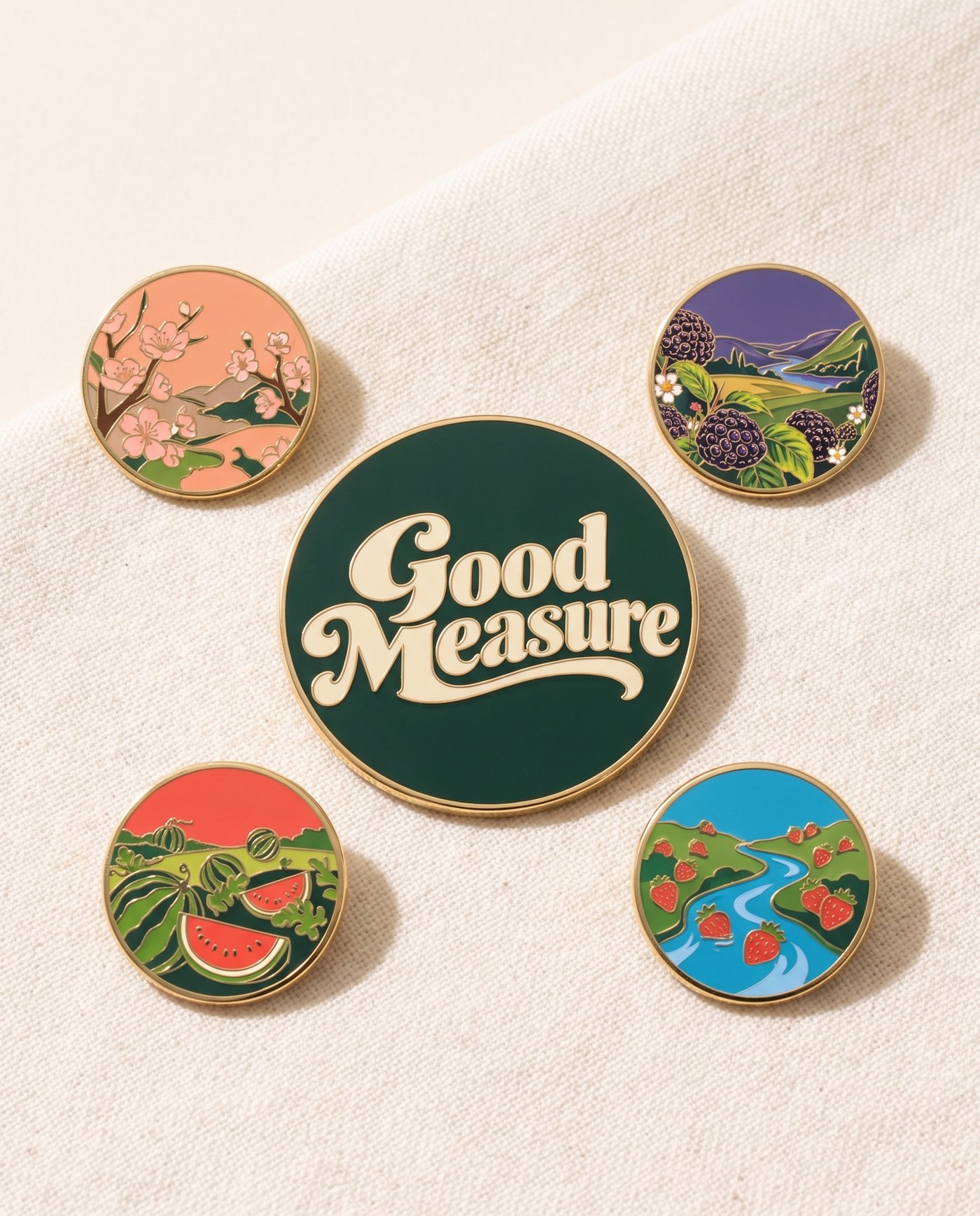 Four Worlds Pin Set: Four hard-enamel landscapes and the wordmark, gold edged.