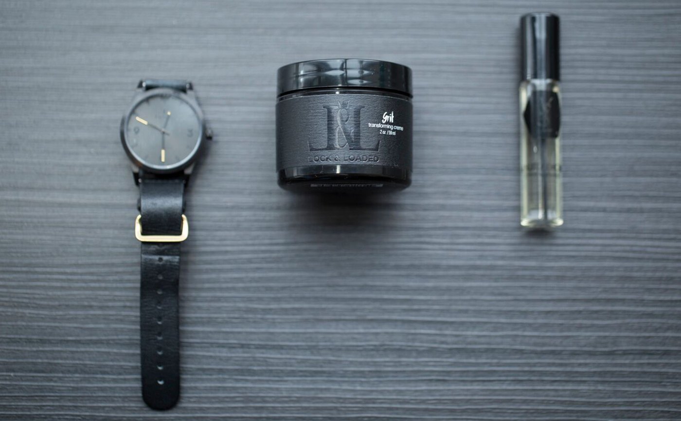 Grit beside a watch and cologne