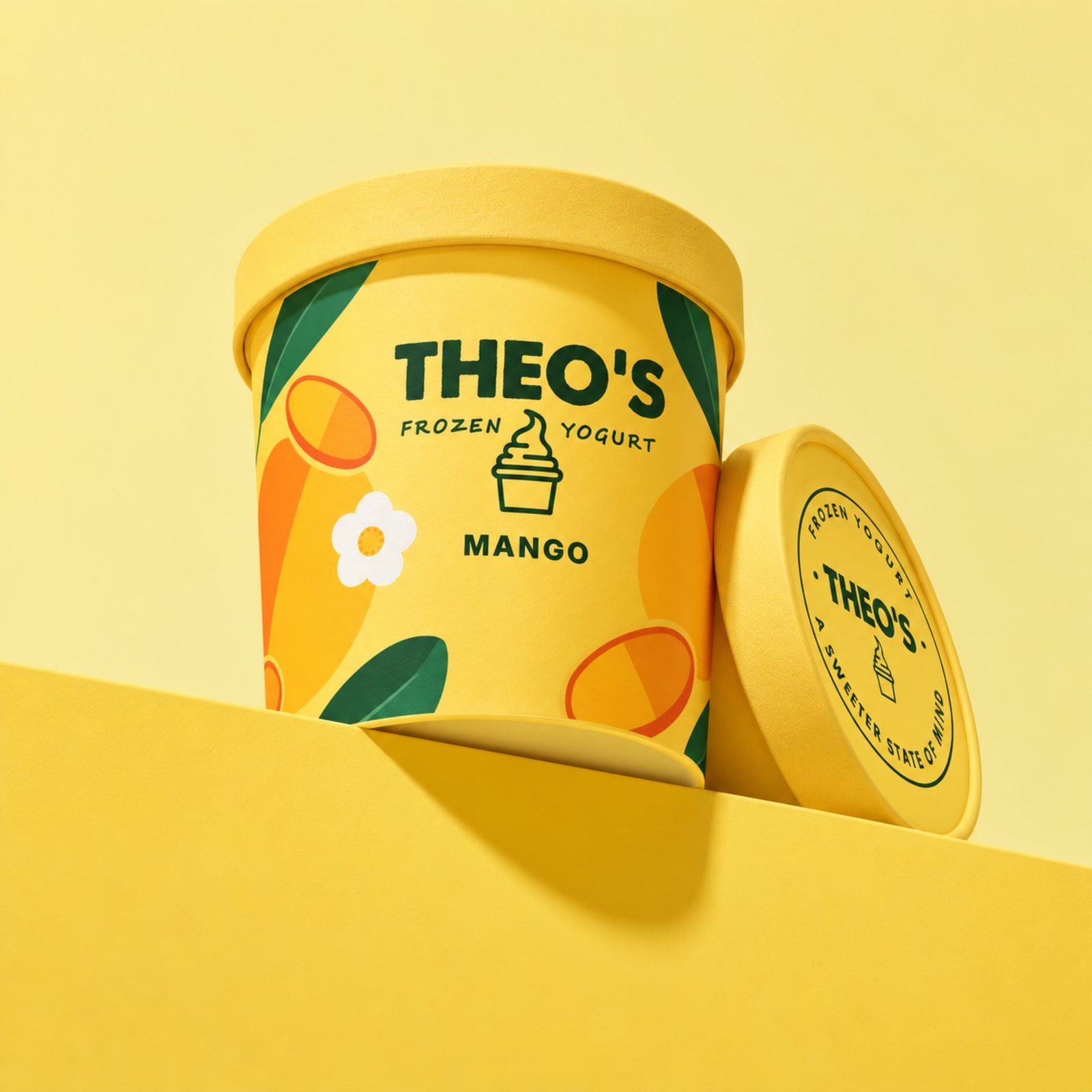 A Theo’s Mango pint on a yellow ledge against a yellow wall, its lid leaning beside it