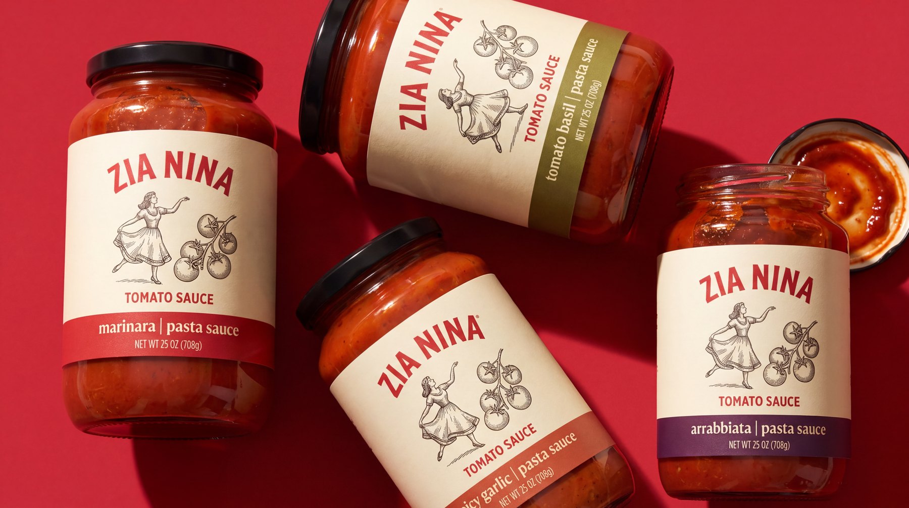 Four Zia Nina sauce jars lying and standing on a red ground, one lid off